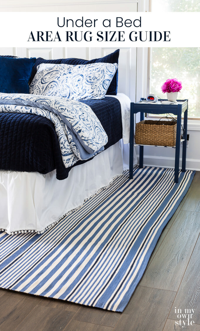 Dormitorio decorado en azul y blanco con alfombra a rayas azules y blancas debajo de la cama.